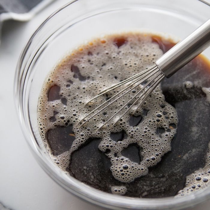 soy sauce mixture for beef and broccoli in a bowl with whisk