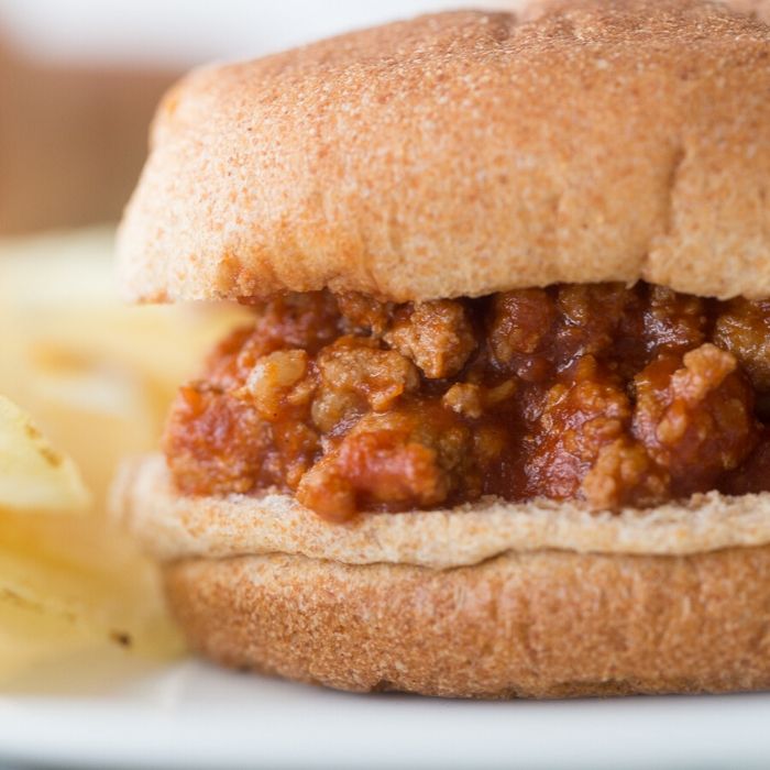 sloppy joe on a plate with chips by it 