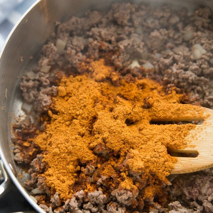 gorund beef in skillet with taco seasoning on top 