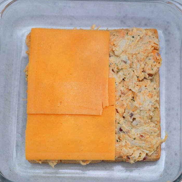 chicken in a pan with sliced cheese on top 