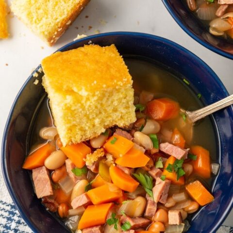 bowl of ham and bean soup with cornbread on top