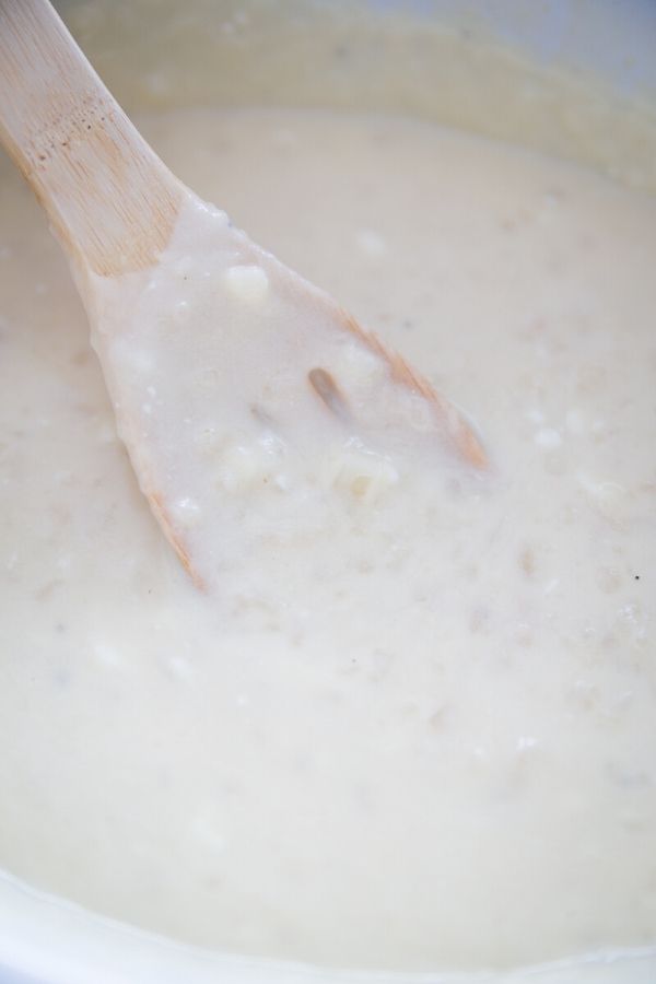 crock pot potato soup with wooden spoon in crock pot