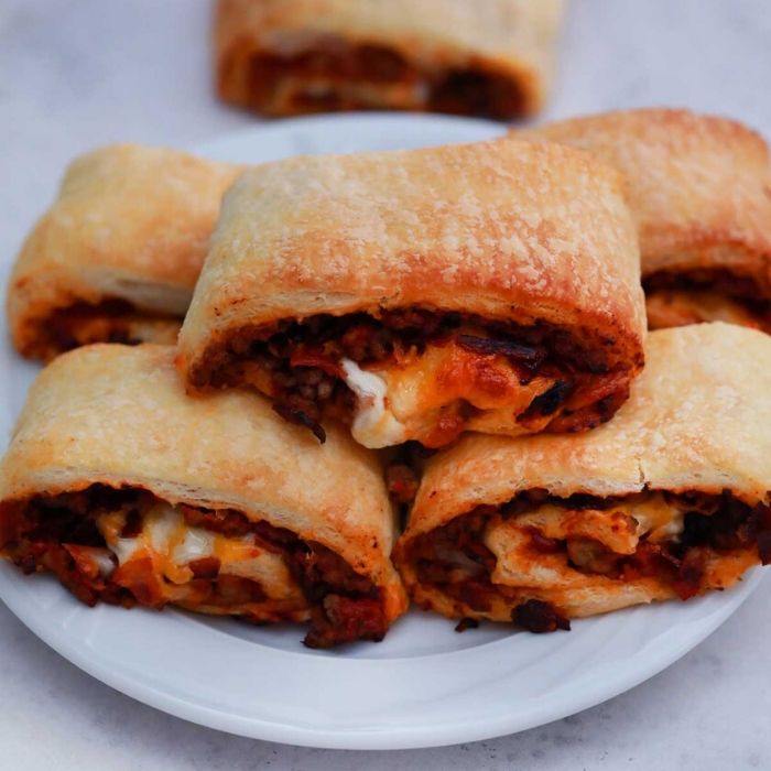 bacon cheeseburger pinwheels on a plate stacked up 