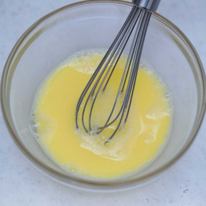 egg wash in a glass bowl with whisk