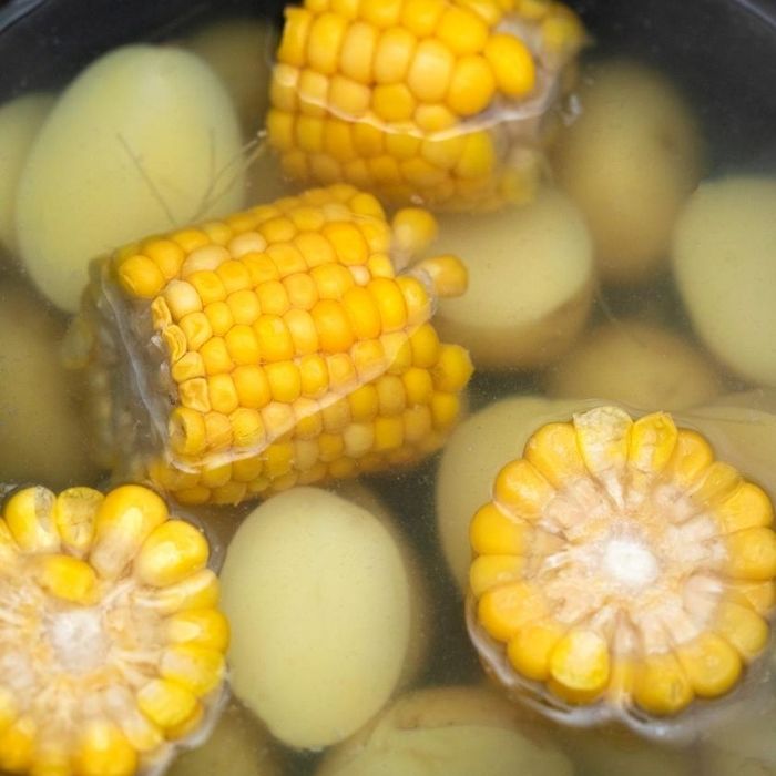 potatoes and corn in a pot of water