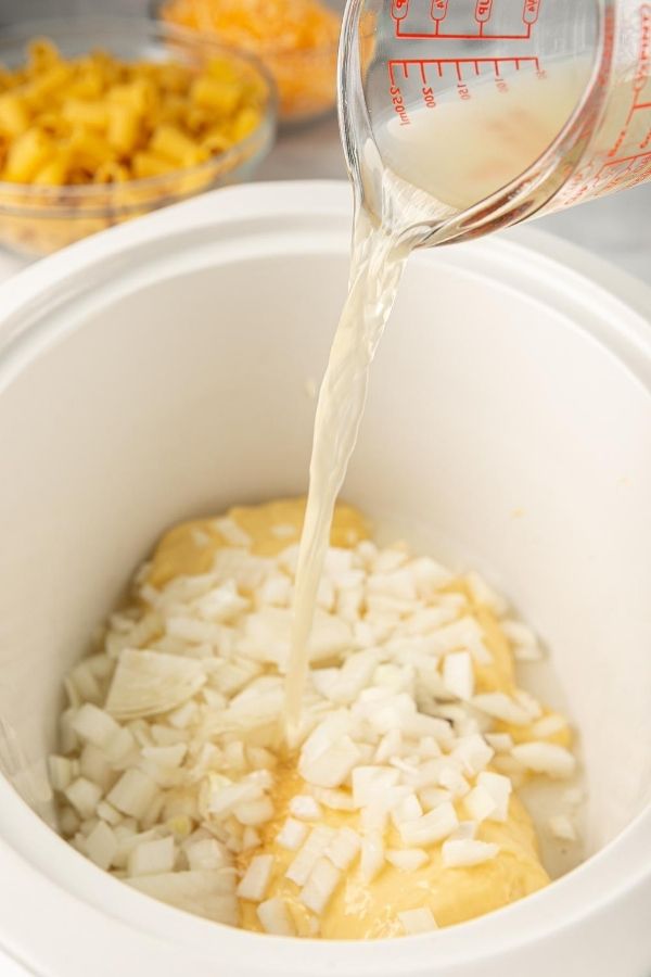 broth being poured into slow cooker 
