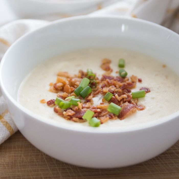 slow cooker potato soup in a bowl topped with bacon