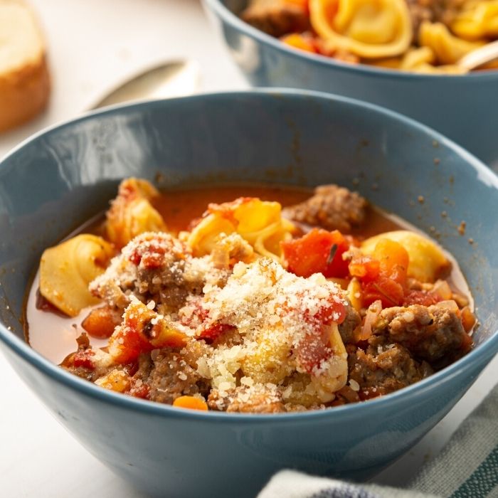 tortellini soup in a blue bowl 
