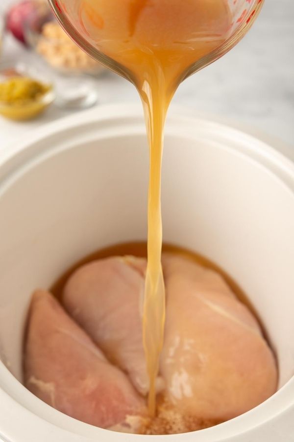 pouring broth into the slow cooker
