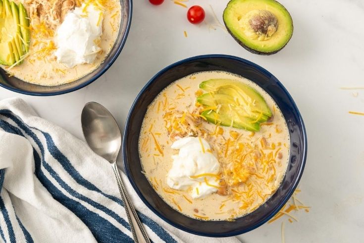 chicken chowder in a bowl with avocado by it