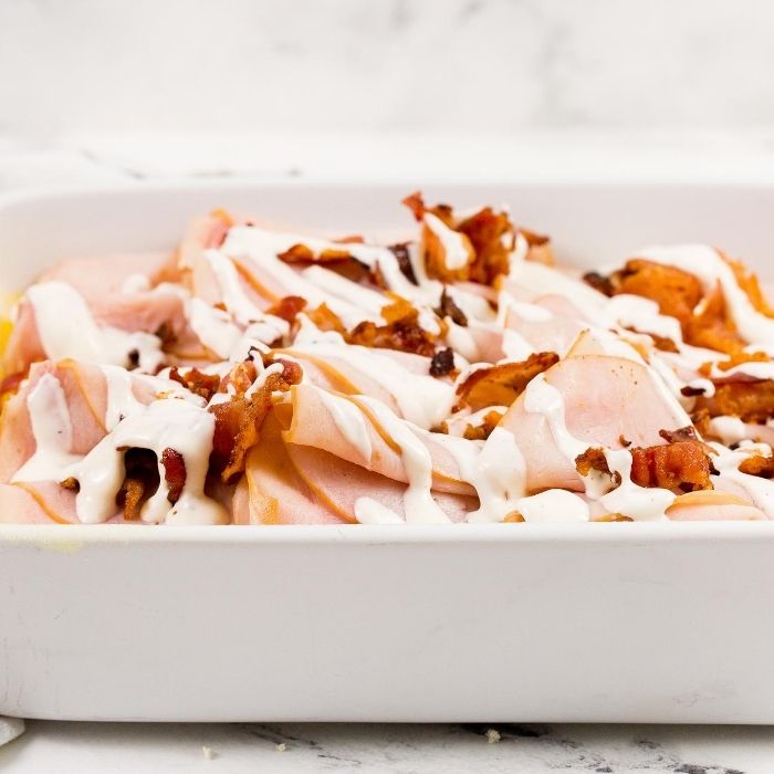 turkey and bacon on top of rolls drizzled with ranch 