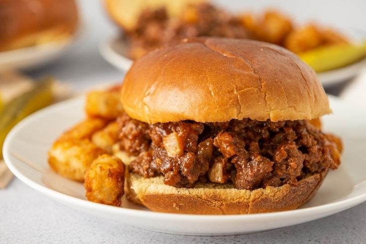 sloppy joe on a plate with tots by it