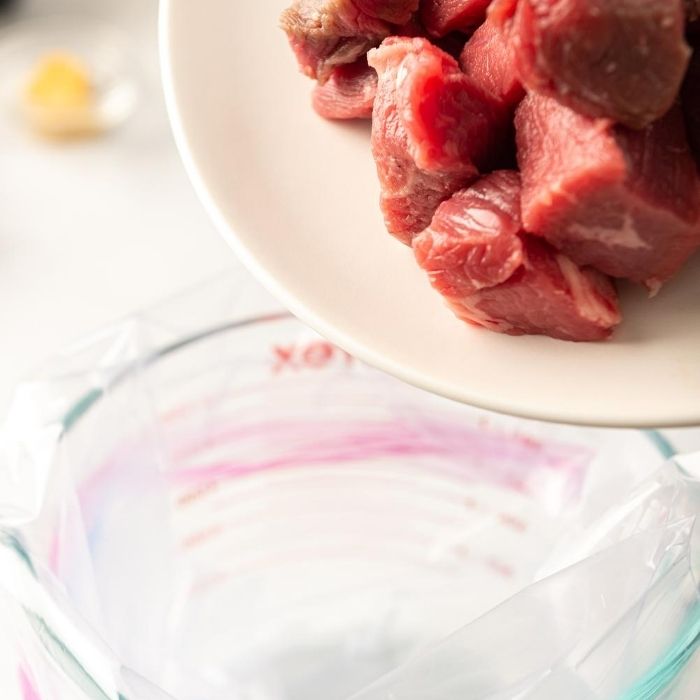 steak being dumped into sealable bag