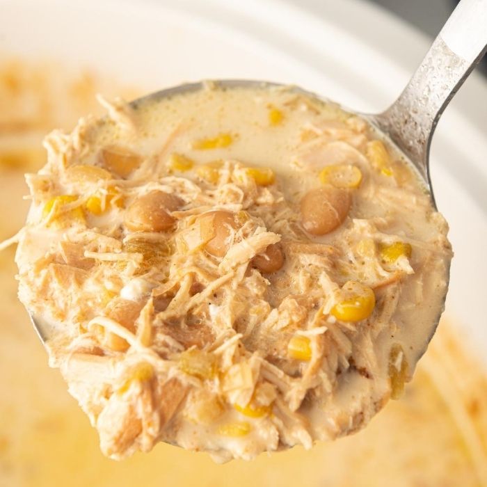 ladle of creamy chicken soup over slow cooker