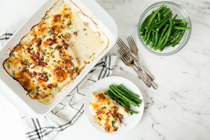 crack chicken in pan and plate with vegetables by it