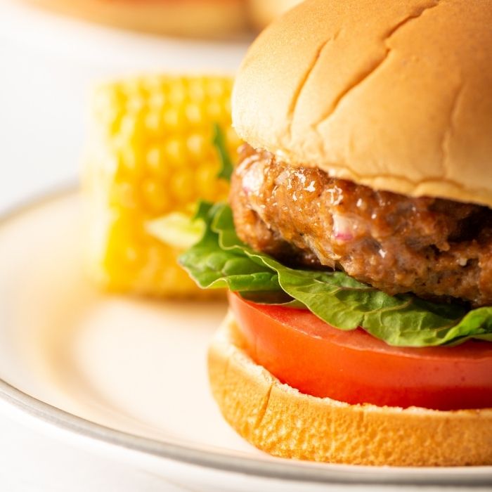 ground turkey burger on plate with corn 