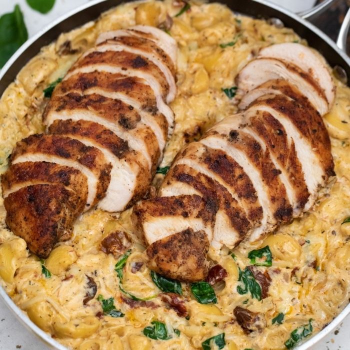 cheesy macaroni with chicken sliced on top