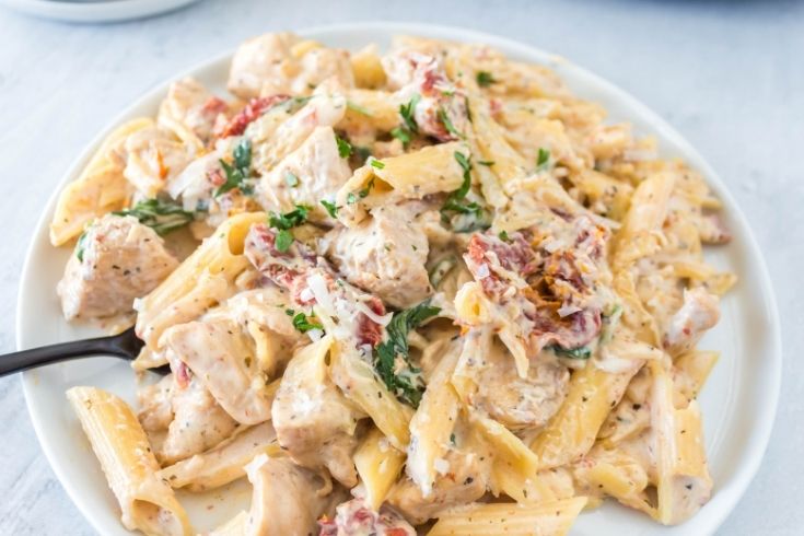 plate of chicken Tuscan pasta with fork in it