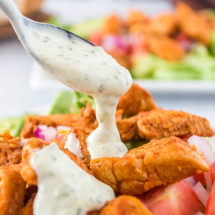 spooning dressing on top of chicken