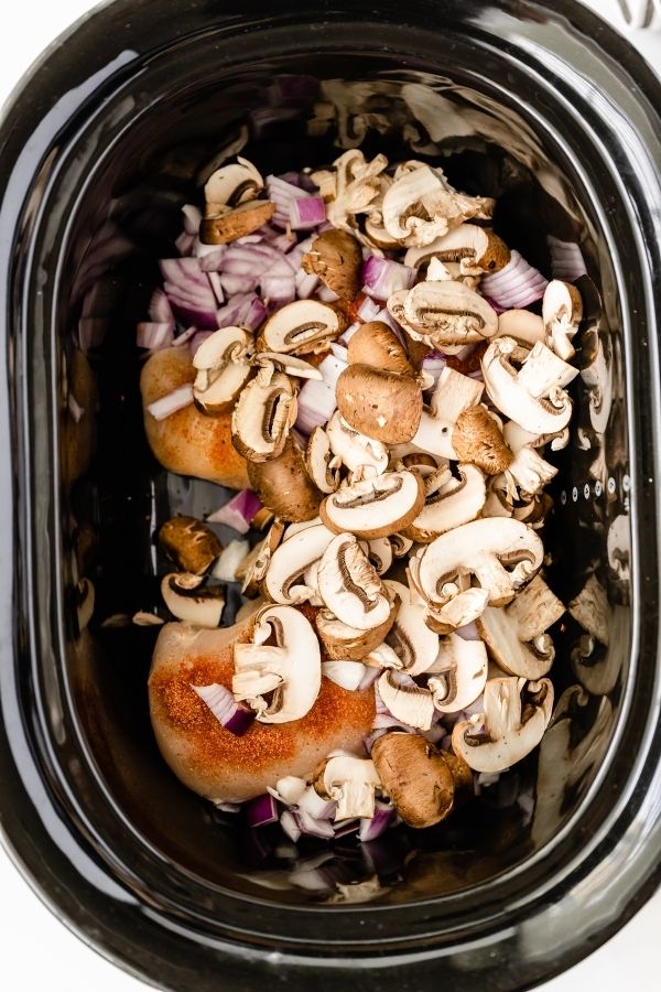 slow cooker with chicken and mushrooms in it