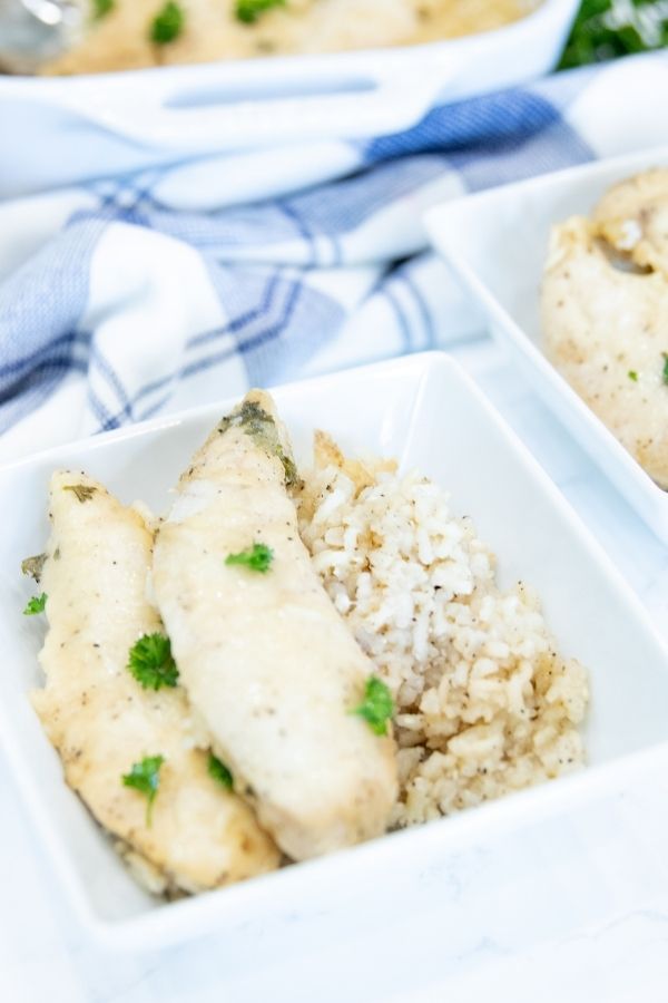 casserole with chicken in a bowl with other plates behind it 
