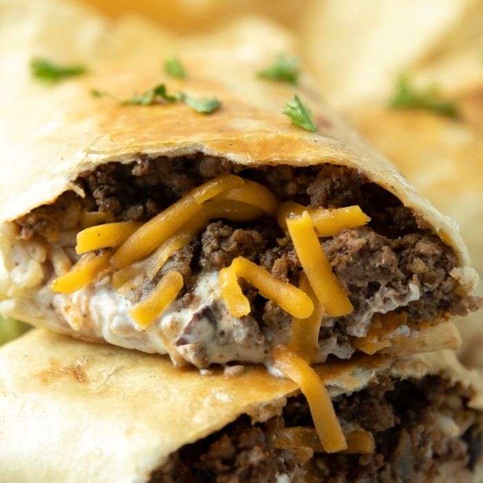 ground beef burrito cut in half stacked on top of each other 