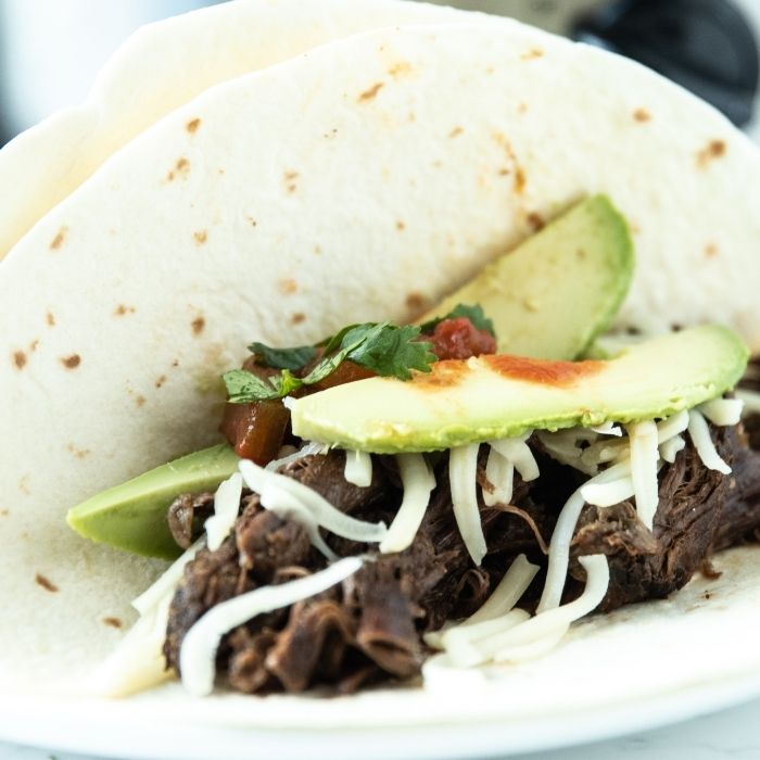 homemade carnitas with avocado and cheese on top 