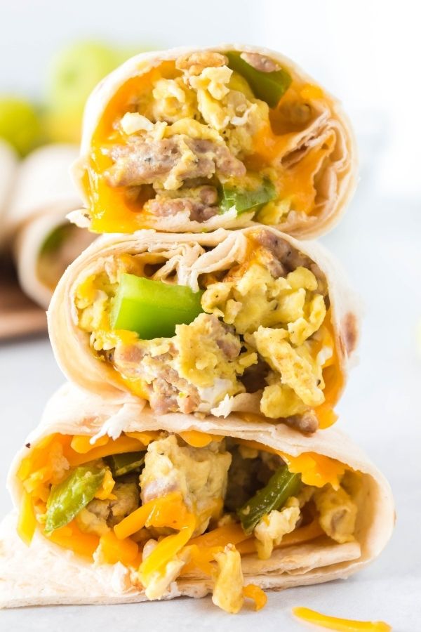 homemade sausage breakfast burritos stacked on top of each other