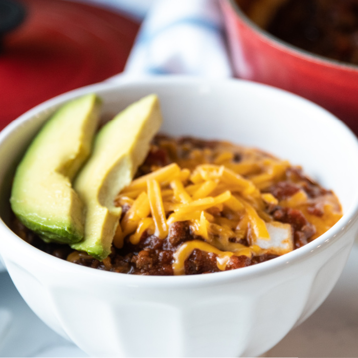 low carb chili in a bowl with cheese and avocado on top