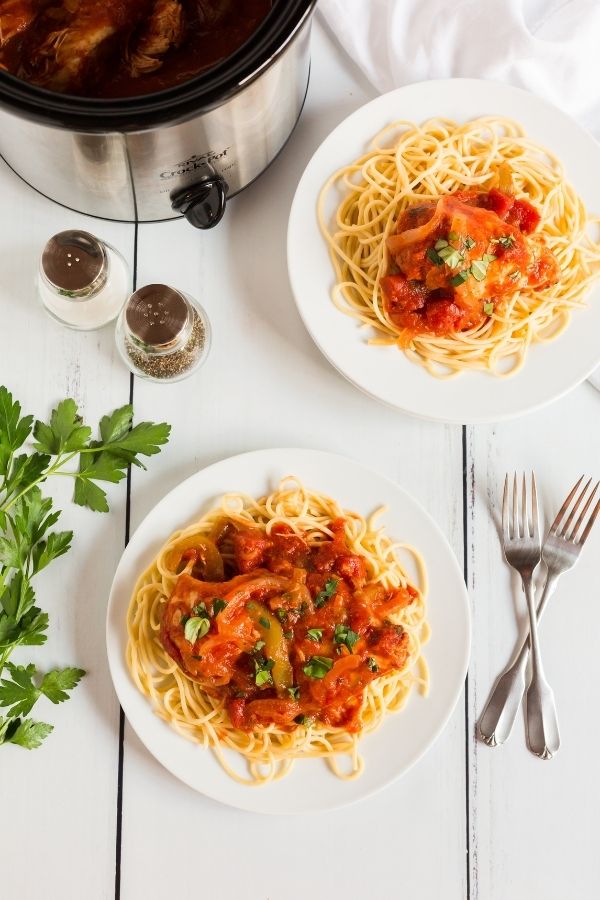chicken caicattore on plates with silverware by it 