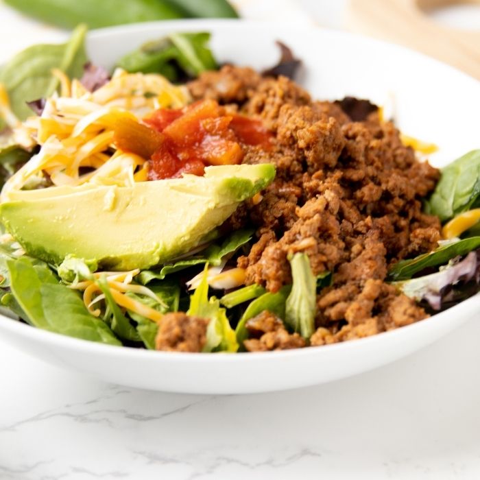 close up view of taco salad in a white bowl 