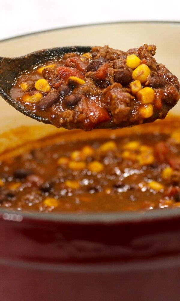 wooden spoon with chili over a bowl 