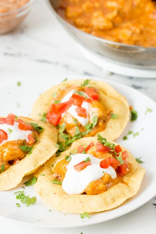 tostadas on a plate with pan behind it 