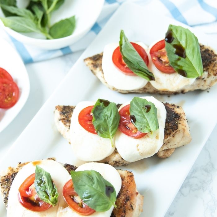chicken caprese on counter with basil tomato