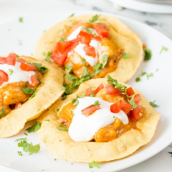 tostadas chicken topped with sour cream and tomatoes