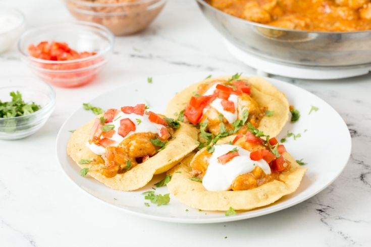 tostadas on a plate with toppings in bowls beside it