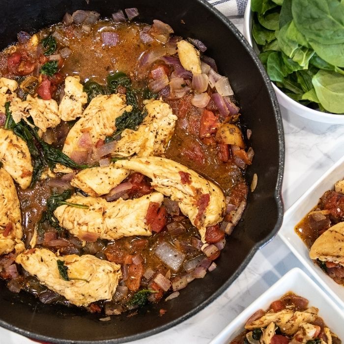 chicken skillet dish with bowls of it beside it