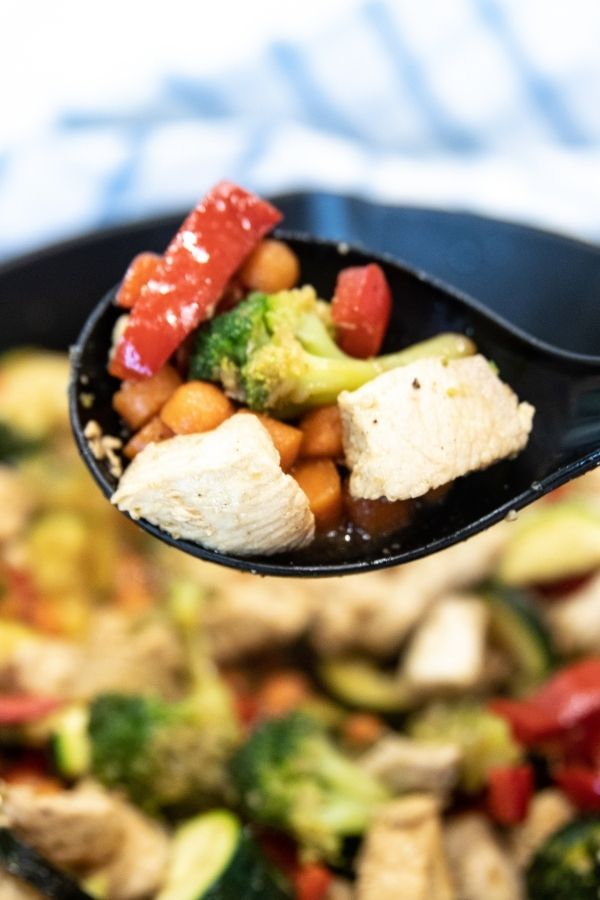 spoon with chicken and veggies on it 